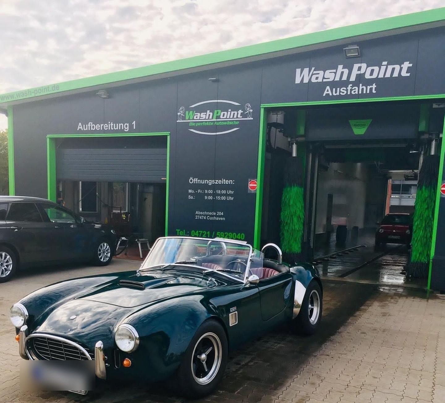 Die beiden Hallentore von WashPoint in Cuxhaven, davor ein dunkelgrüner Roadster