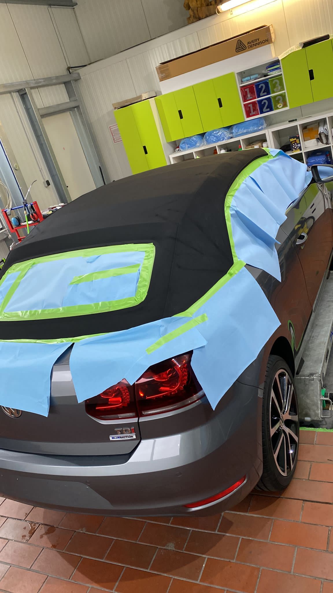 Fahrzeugheck mit blauem Klebeband abgeklebt, vorbereitet für die Lackarbeit